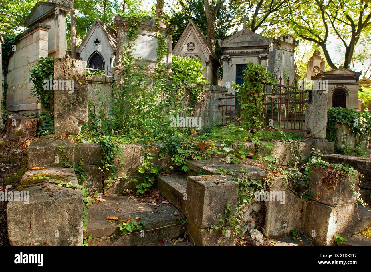 Bewachsene Stufen führen zu einer Reihe von Mausoleen auf dem historischen Pariser Friedhof Père Lachaise. Stockfoto