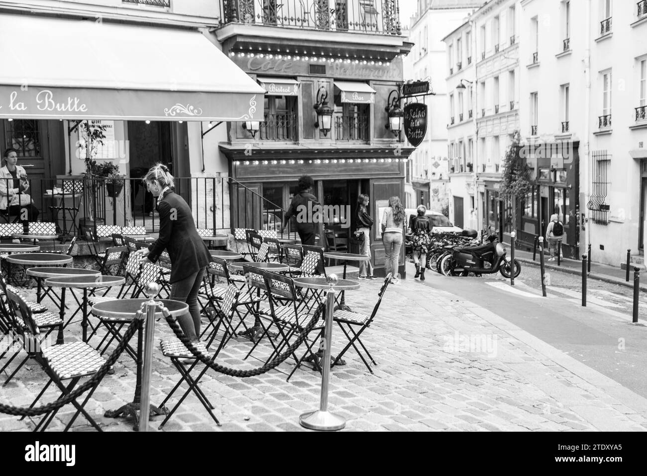 Kellnerin arrangiert Tische in einem Restaurant im Freien in Paris, Frankreich Stockfoto