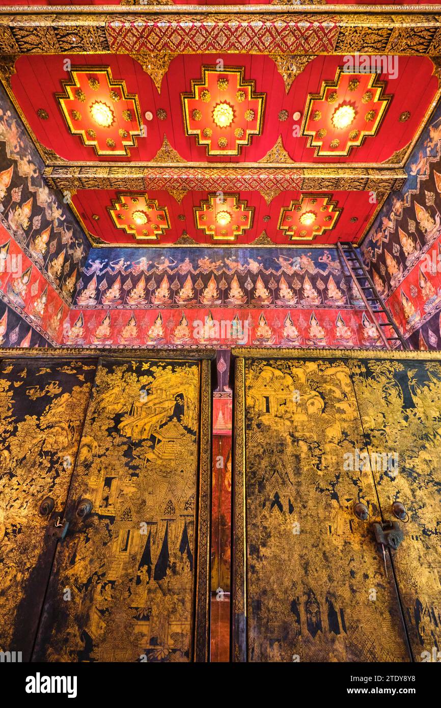 Gemalte Details, ein goldener und schwarzer Schrank und eine komplizierte Decke. Im Inneren des roten, reich geschmückten buddhistischen Tempels der Buddhaisawan Hall. Im National M Stockfoto