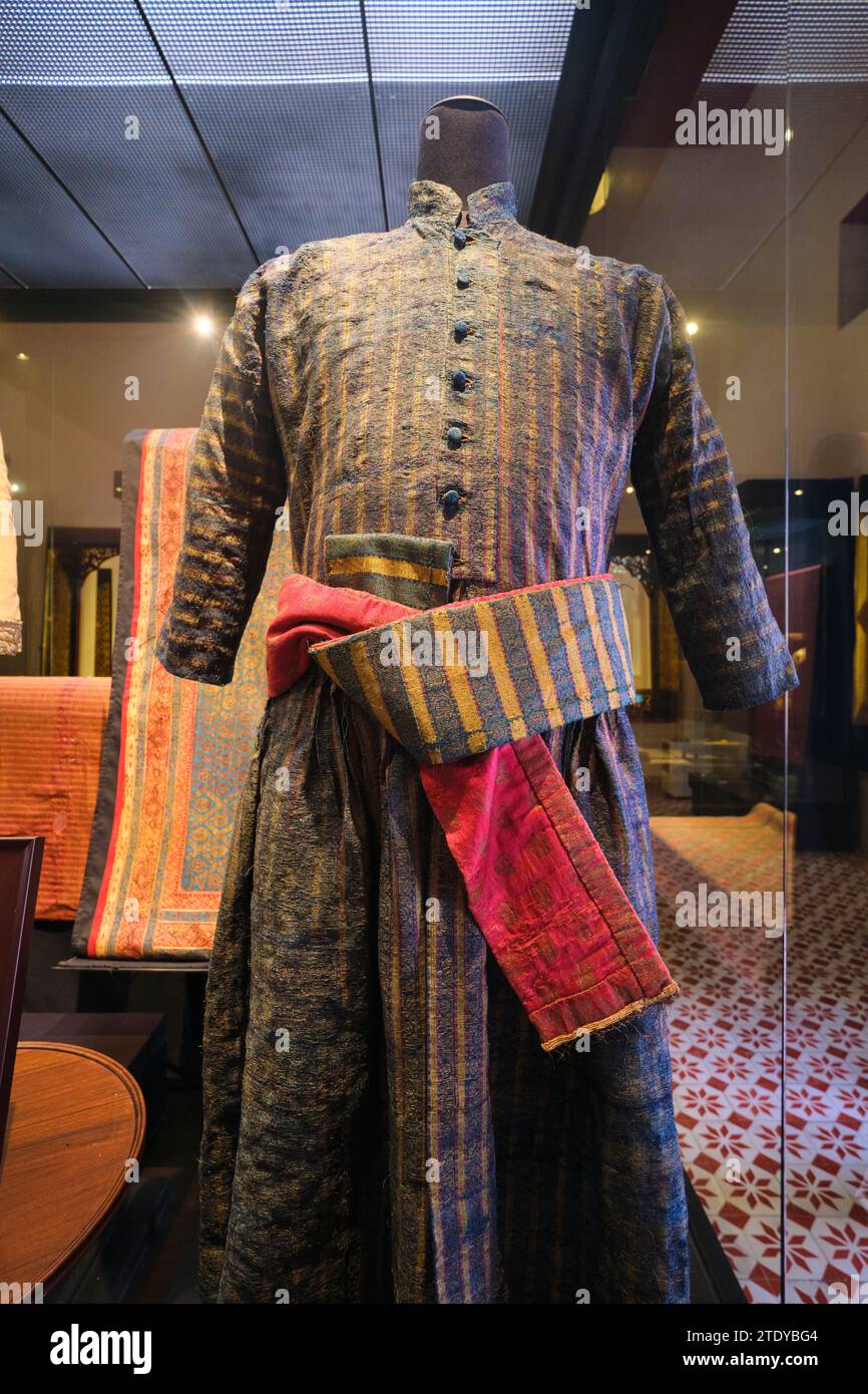 Ein wunderschöner königlicher, traditioneller Stoff, Textil, gewebter Mantel und roter Schärpe. Im Nationalmuseum in Bangkok, Thailand. Stockfoto