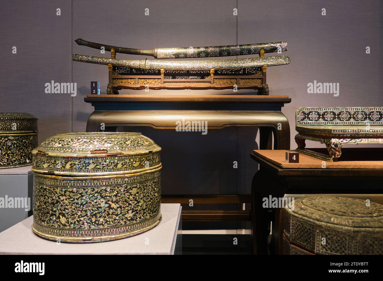 Eine Ausstellung von zeremoniellen Schwertern und anderen verschiedenen Gegenständen im Intarsien-Design der Perlmutt. Im Nationalmuseum in Bangkok, Thailand. Stockfoto