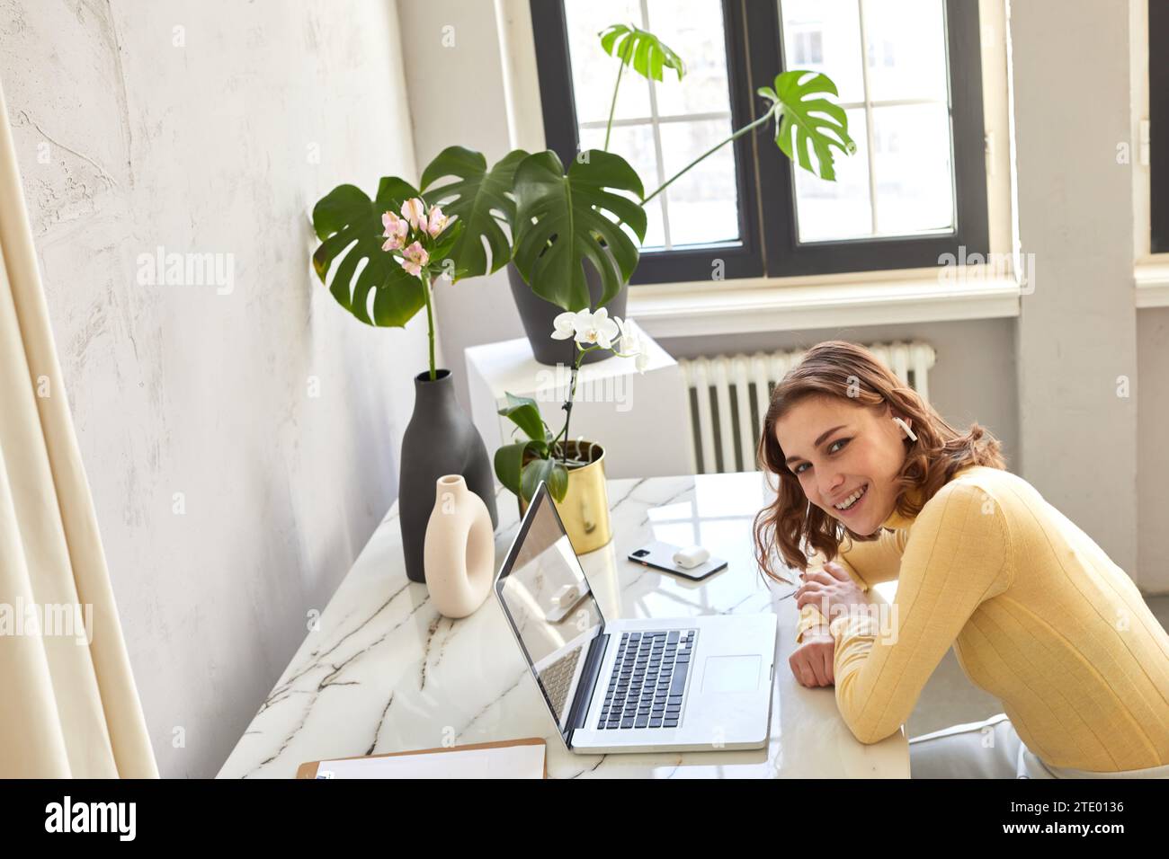 Lächelnde Freiberuflerin, die zu Hause am Laptop arbeitet Stockfoto