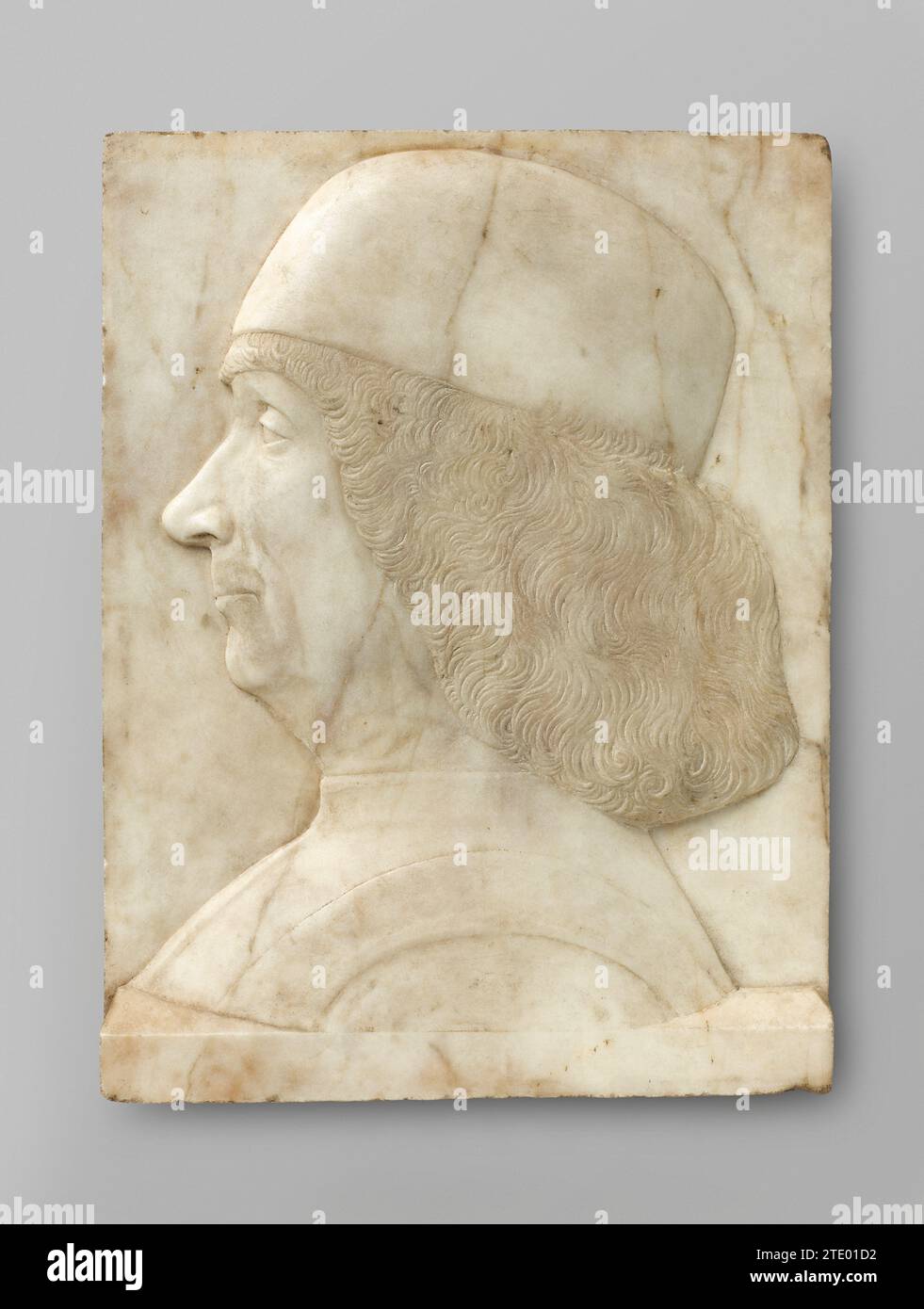 Porträt von Gentile Bellini, Tullio i Lombardo (zugeschrieben), um 1500 der Mann ist links in der Brust dargestellt. Er trägt einen Calot auf dem dicken Haar, das Stirn, Ohren und Hals bedeckt; außerdem eine schmale Stange mit einer bandförmigen Verdickung an den Schultern (ein Schulterventil?). Das ganze ruht auf einem leicht vorstehenden, schrägen Sockel. Venezianischer Marmor (Felsen) der Mann wird links zur Brust gezeigt. Er trägt einen Calot auf dem dicken Haar, das Stirn, Ohren und Hals bedeckt; außerdem eine schmale Stange mit einer bandförmigen Verdickung an den Schultern (ein Schulterventil?). Die gesamte r Stockfoto