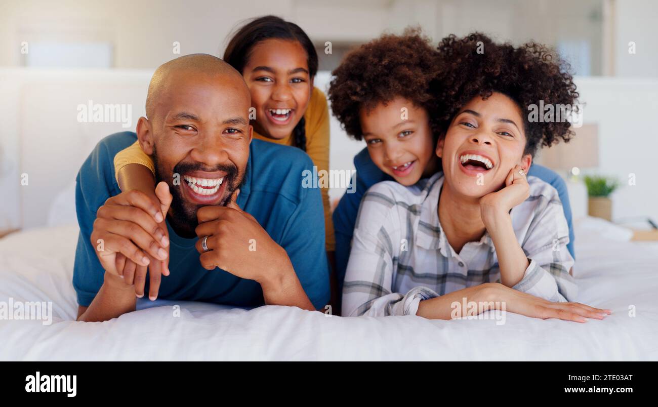 Lächeln, Porträt und Kinder mit Eltern im Bett eines modernen Heims zum Binden mit Teddybären. Glücklicher, lustiger und junger Mann und Frau Stockfoto