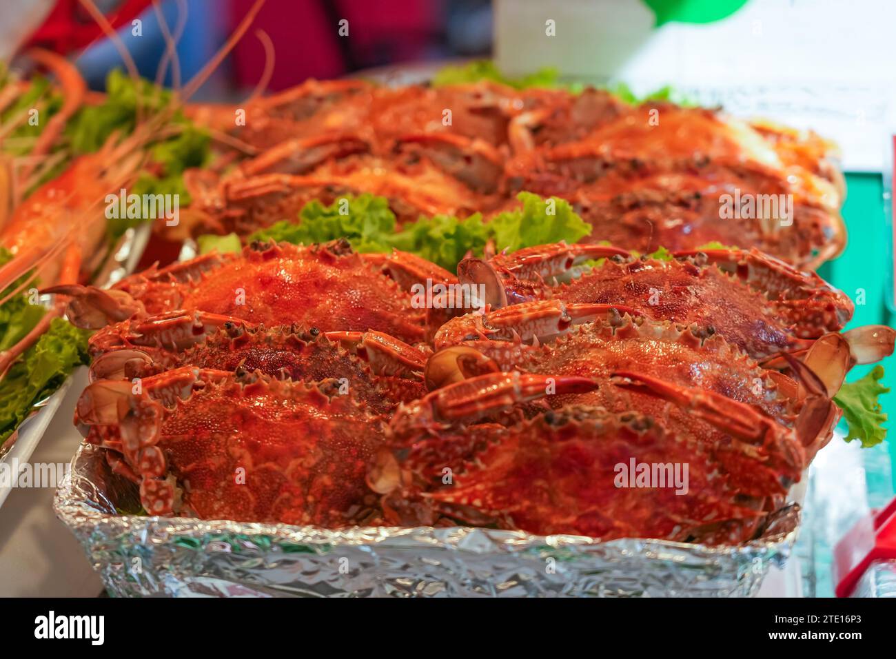 Gekochte große Krabben und Riesengarnelen mit grünem Salat von Gerichten an einem Street Food Stand Stockfoto