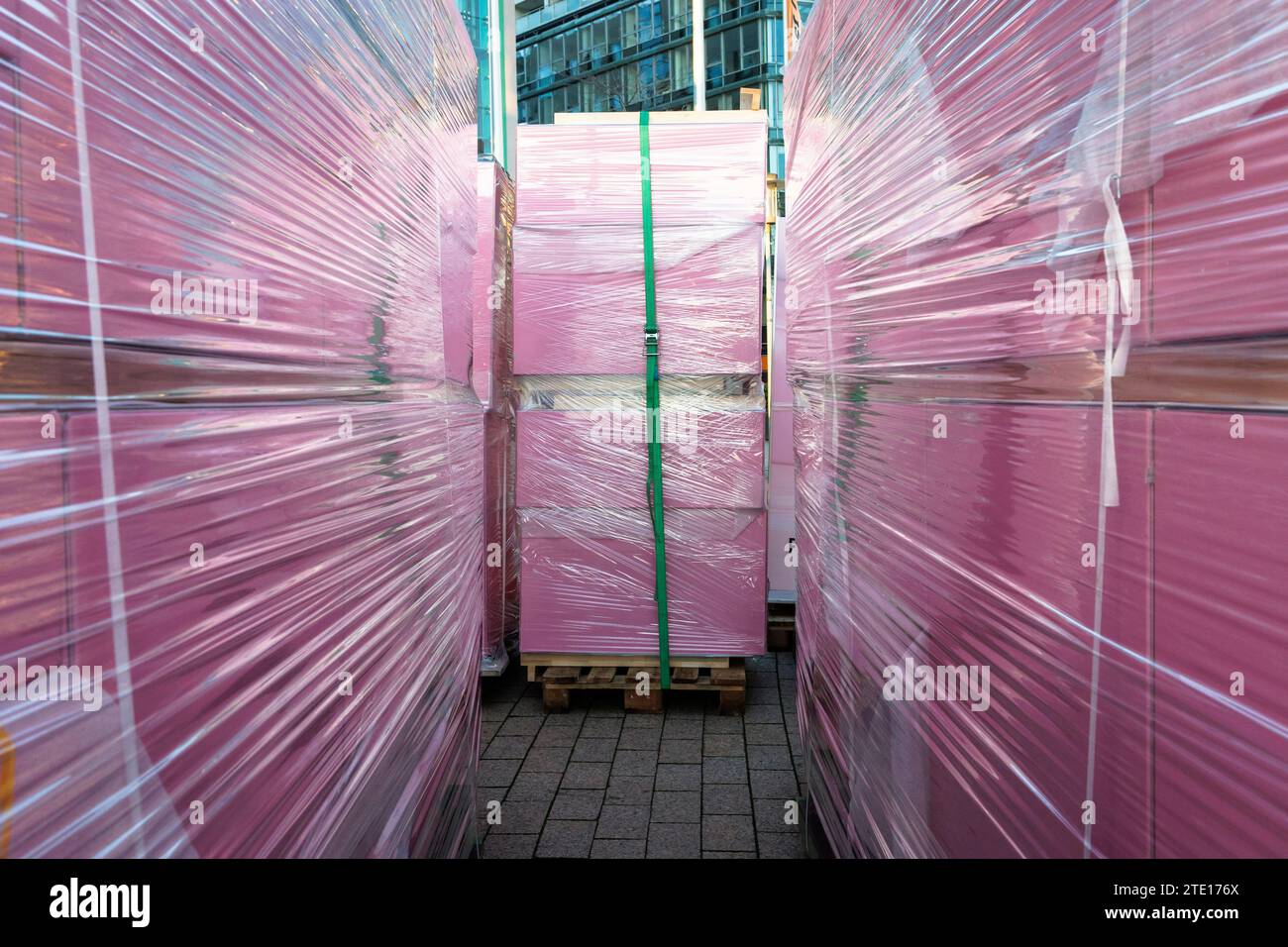 Pinkfarbene Boxen in Folie auf Paletten für Transport, Köln, Deutschland. In Folie eingepackte rosa Kisten stehen auf Paletten zum Abtransport, Koel Stockfoto