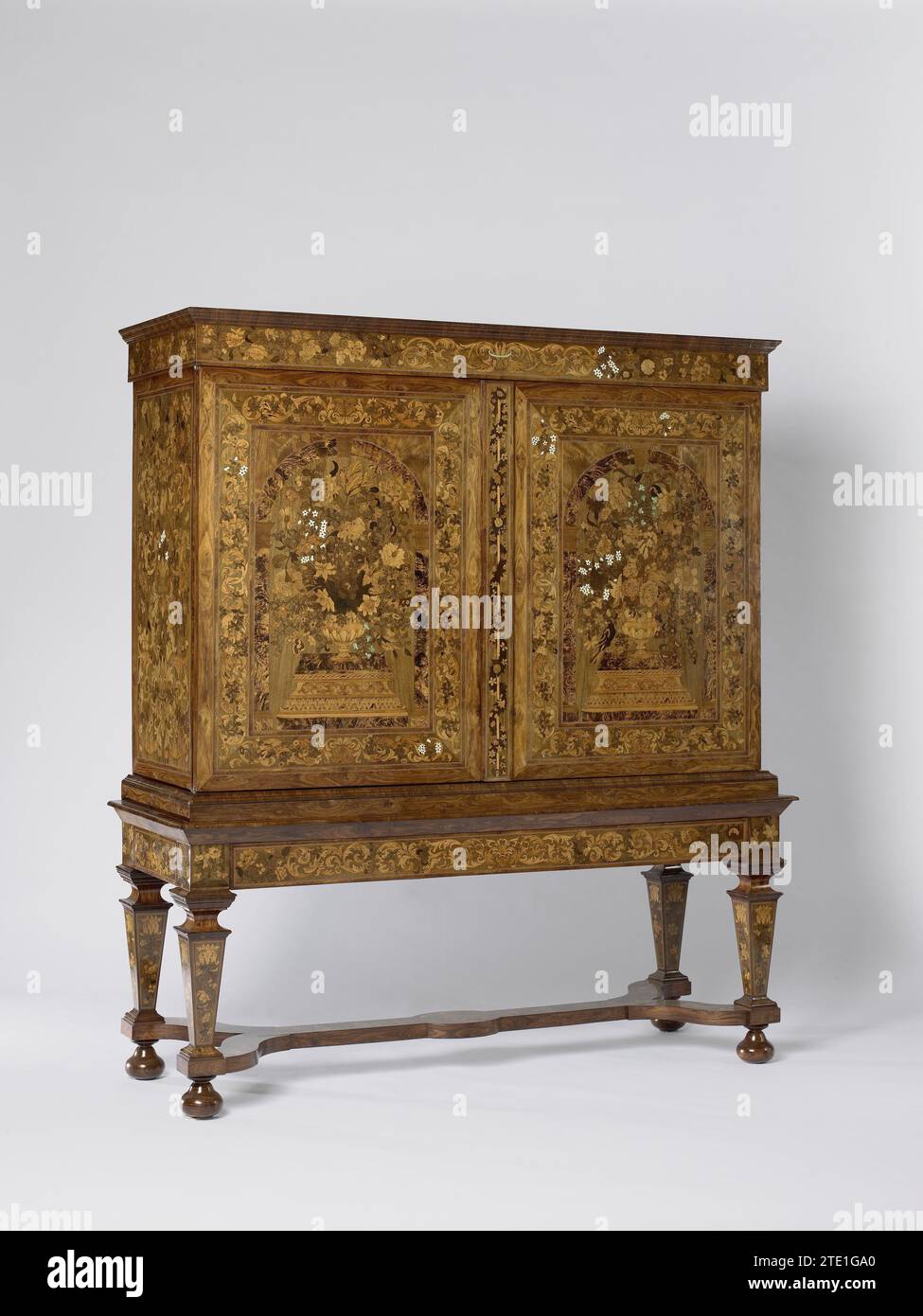 Schrank, anonym, ca. 1685 - ca. 1700 Schrank mit mehreren Hölzern und Beinen auf Eichenkern geklebt. Die Balusterbeine des Fahrgestells sind durch ein doppeltes Y-förmiges Kreuz an bol-Beinen mit einem Oval in der Mitte verbunden. Sowohl die Innen- als auch die Außenseite der Möbel und der Rahmen sind mit Blumen-Marqueterie dekoriert. Die beiden Türen zeigen hohe Blumenvasen unter Bögen, die hoch auf Podest platziert sind; auf jedem Podest befindet sich ein Vogel. Rahmen mit Blumen- und Blattreben. Die Regel des Fahrgestells enthält eine Schublade an der Vorderseite. Amsterdam (möglicherweise) Holz (Pflanzenmaterial). Eiche (Holz). palisander (Holz). Nussbaum (Hartholz). Stockfoto