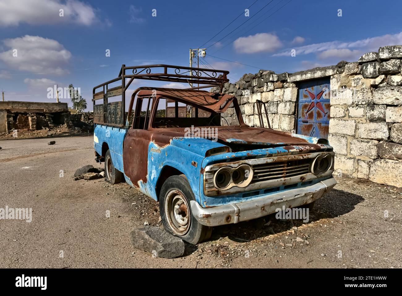 Ein verlassenes Fahrzeug in den römischen Ruinen von Bosra (Gebiete, die von der Freien syrischen Armee (FSA) kontrolliert werden), Syrien Stockfoto