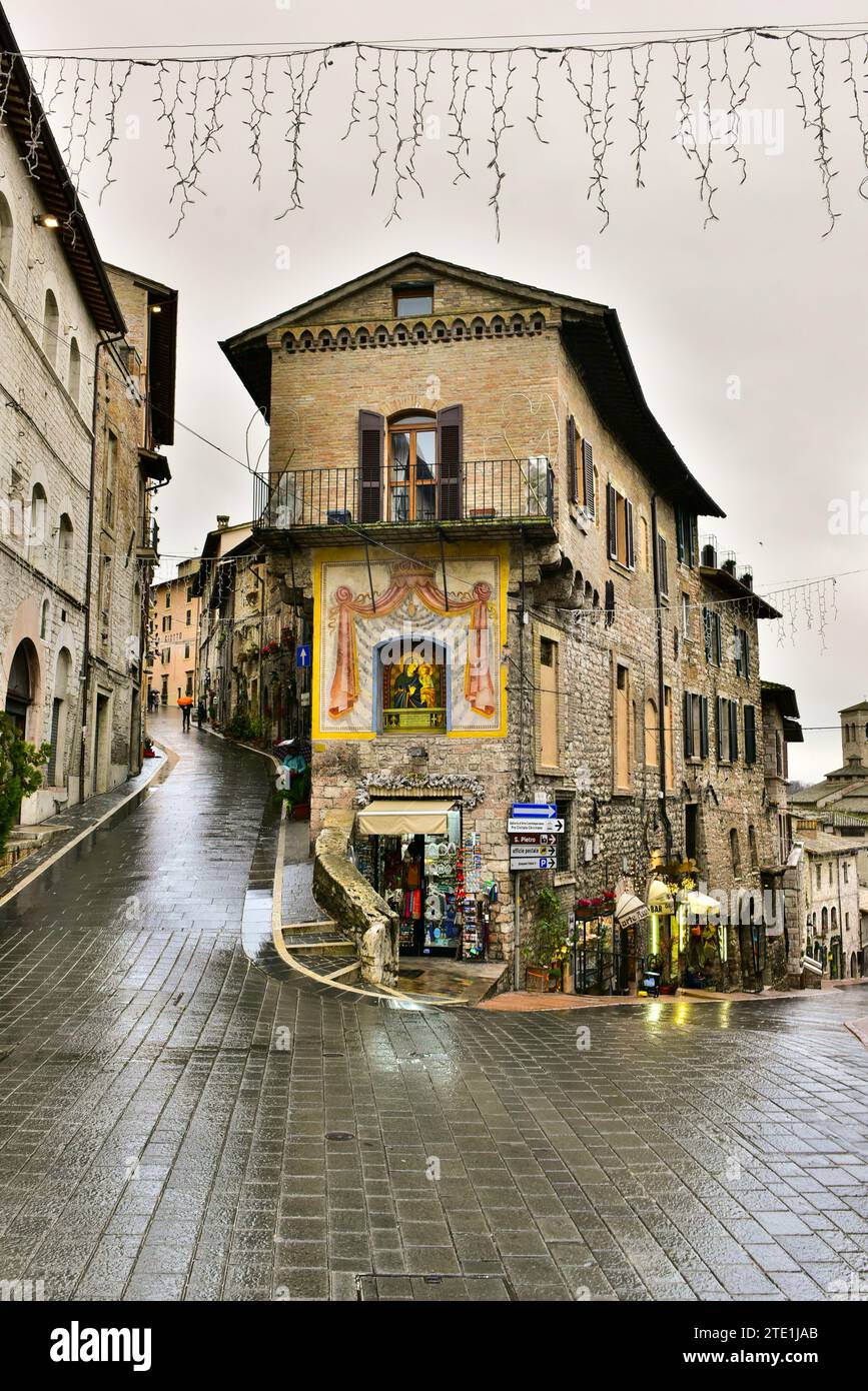 Ein Schrein in einem Gebäude an der Piazzetta Ruggero Bonghi aus Porta San Francesco. Assisi, Umbrien, Italien Stockfoto
