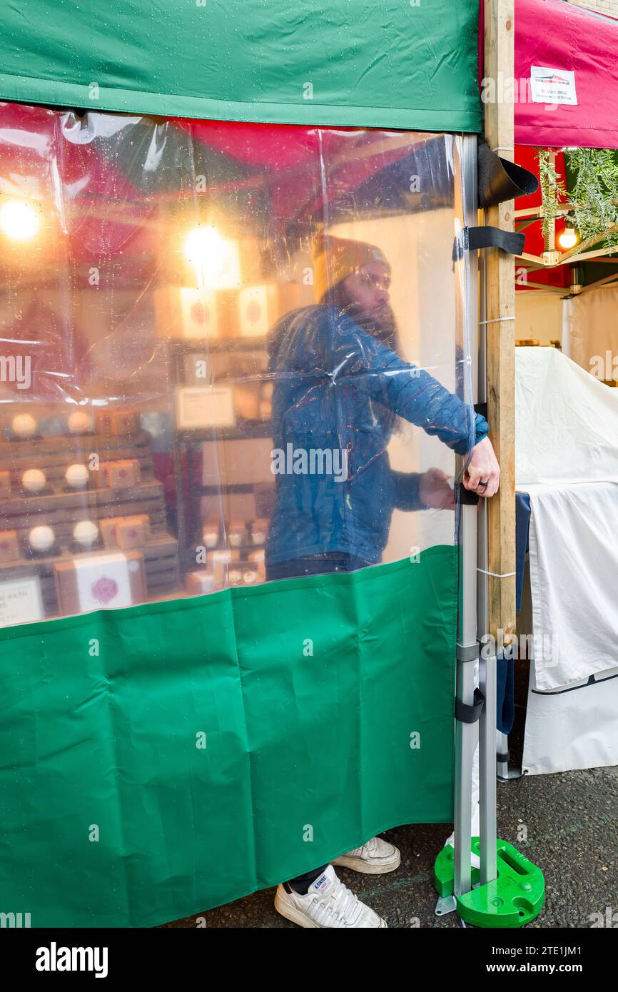 Ein Stallhalter, der zu Beginn des Tages seine Stände ablegt, Weihnachtsmarkt, Oxford, england Stockfoto