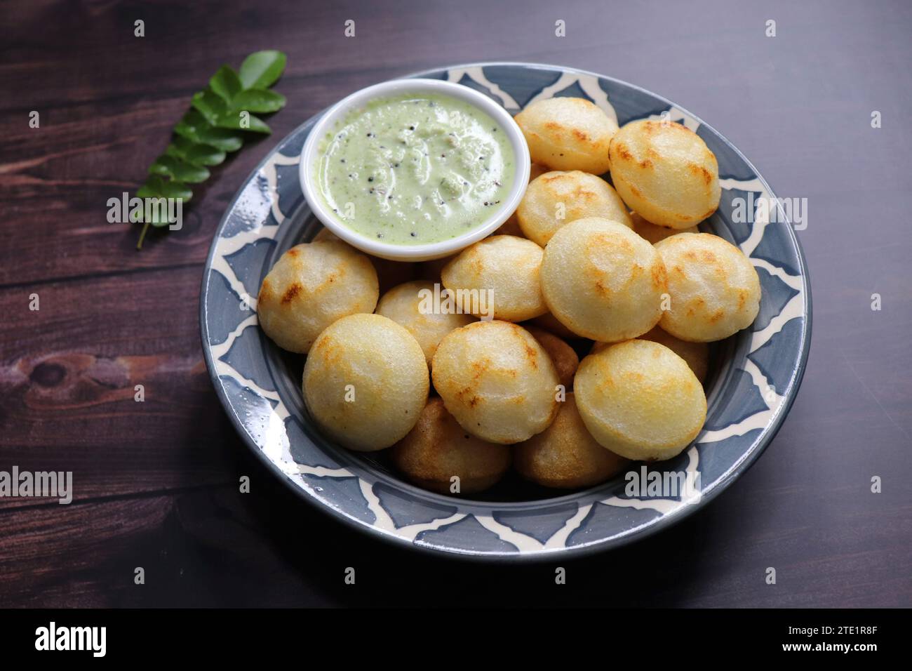 Paniyaram sind herzhafte Bällchen, die aus fermentiertem Reis und Urad dal Teig zusammen mit temperierten Zwiebeln und Gewürzen hergestellt werden. Auch bekannt als Paddu, APE. Stockfoto