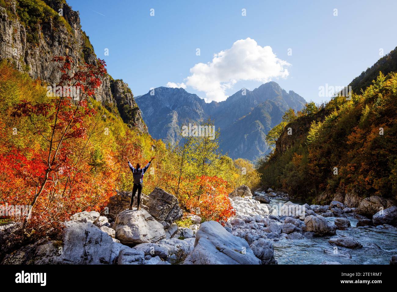 Frau mit erhobenen Armen, die in den bunten albanischen Alpen steht Stockfoto