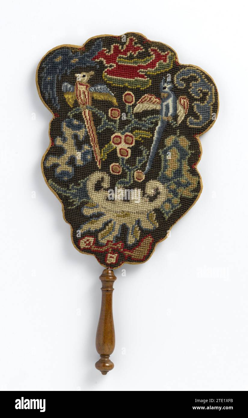 Feuerschutzgitter aus Leinen, angespannt über Skulpturen, Holz (?) Rahmen, vorne mit mehrfarbiger Wolle bestickt und hinten mit einem Putto mit einer Blumenschüssel bedruckt, montiert auf Nuthout-Stick, Johan Teyler, ca. 1688 - ca. 1720 der unregelmäßig gewellte Schirm ist vorne mit mehrfarbiger Wolle in Petit-Point und Gros-Point bestickt. In der Mitte des asymmetrisch aufgebauten Musters sitzen zwei Vögel, die sich auf einem Ast inmitten von Blumen- und Blattmotiven tummeln. Die langen Schwänze und die barocke Struktur des Musters sind ungewöhnlich und können nicht auf Beispiele aus Musterbüchern zurückgeführt werden. Die Stockfoto