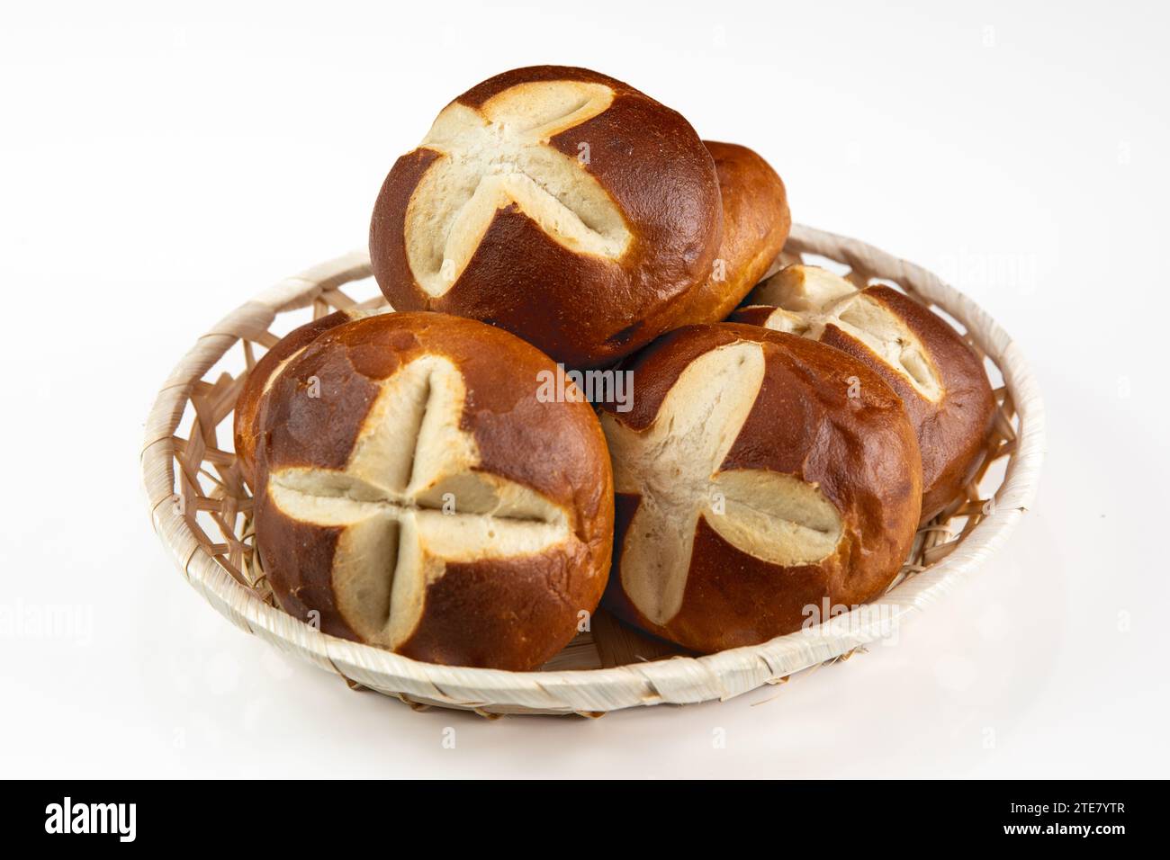 Deutsche Brezelrollen im Korb auf weißem Hintergrund - traditionelles Frühstück Bäckerei-Snack Stockfoto