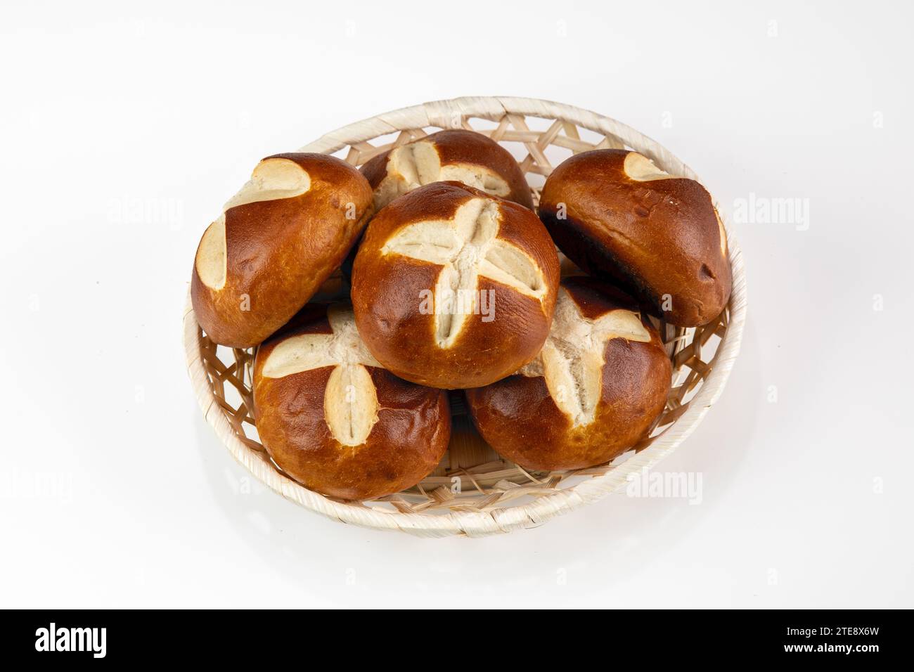 Deutsche Brezelrollen im Korb auf weißem Hintergrund - traditionelles Frühstück Bäckerei-Snack Stockfoto