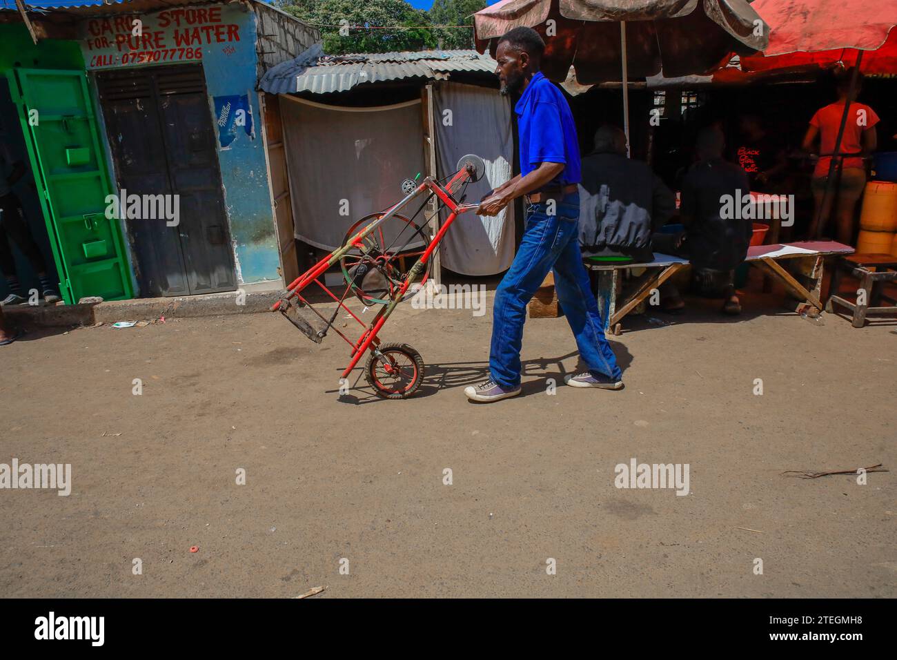 Ein cutler fährt mit seiner Maschine durch die Straßen von Kibera Slum, Nairobi. Ein Blick durch den Alltag in Kibera, derzeit Afrikas größtem Slum und Stockfoto