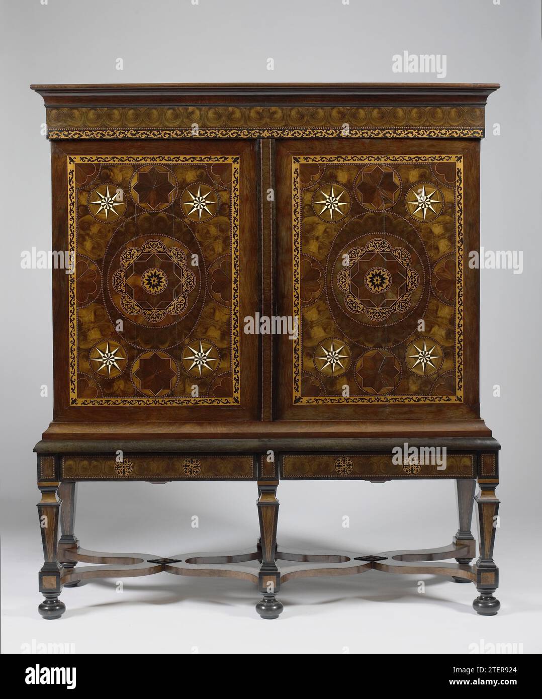 Kabinett, anonym, ca. 1690 - ca. 1710 Eichen-Strongasten mit mehreren Hölzern verklebt. Das Fahrgestell hat sechs Balusterbeine, die durch zwei doppelte U-förmige Kreuze verbunden sind. Die Regel enthält zwei Schubladen, die mit Austernstücken und Mooresken verziert sind. Die beiden oberen Schranktüren und -Seiten zeigen eine Komposition aus Stern- und Rosettenformen auf einem Boden aus Austernstücken, meist in Kreisen. Das ganze ist von Laubreben und französischen Lilien in den Ecken eingerahmt. Friesland mit Austernstücken und Laubstöcken; Schlachtliste mit Austernstücken und Reifen. Niederländisches Holz (pflanzliches Material). Eiche (Holz). palisander (Holz). ebenholz Stockfoto