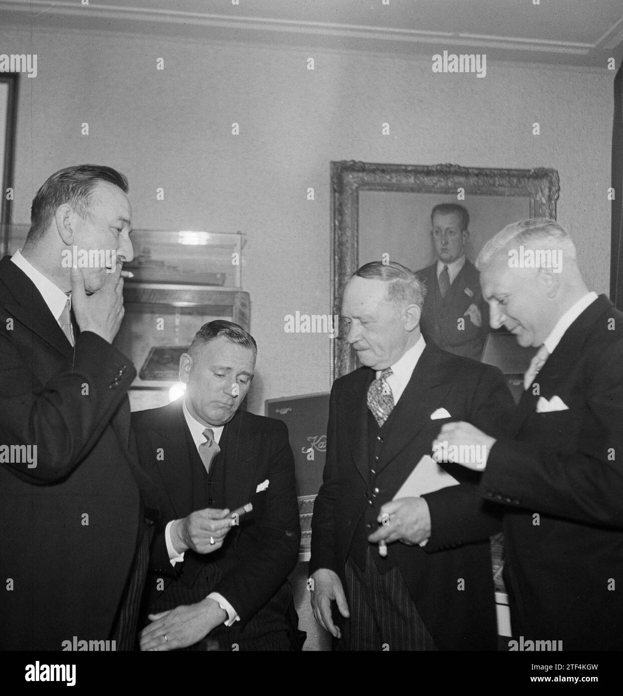 Vier Männer rauchen Zigarren der Marke Karel I, ein Gemälde im Hintergrund ca. 1950 Stockfoto
