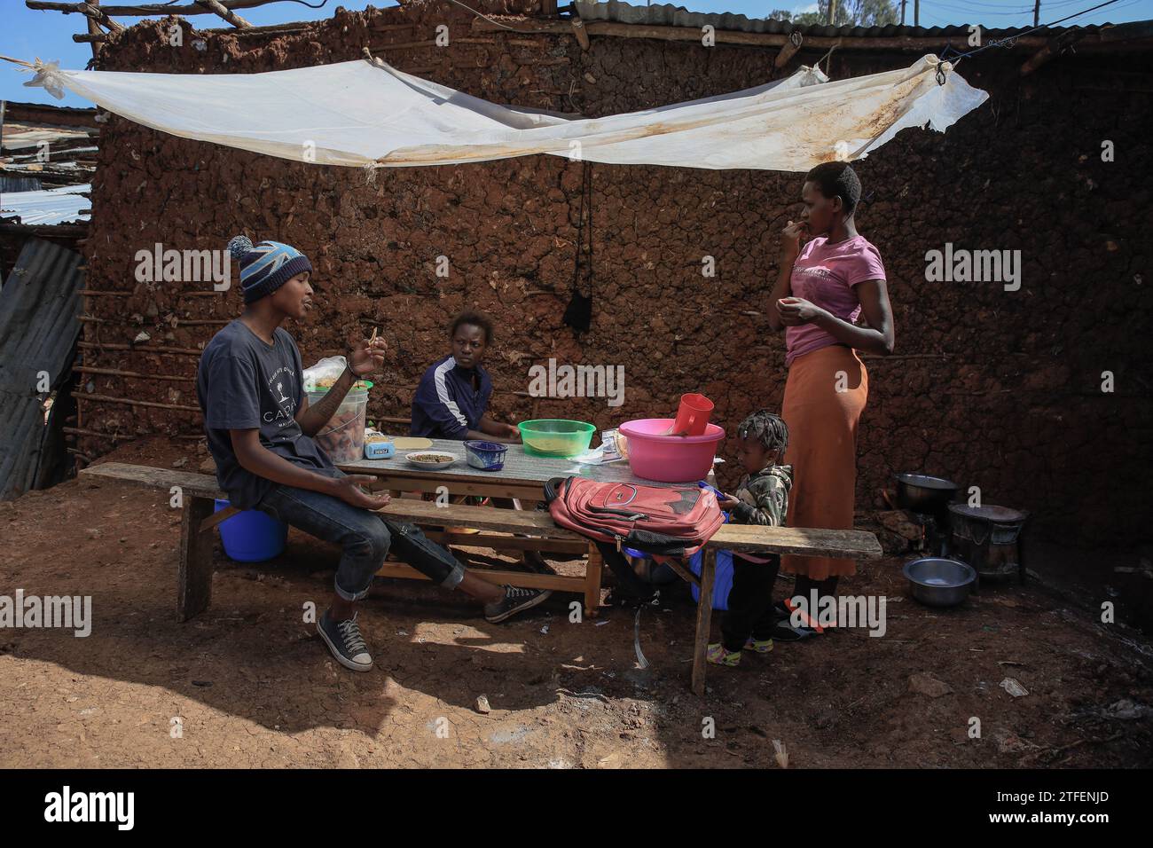 Die Einheimischen nehmen ihr Frühstück in einem offenen Mini-Restaurant in Kibera Slum, Nairobi, ein. Ein Blick durch den Alltag in Kibera, dem heutigen afrikanischen Stadtteil L Stockfoto