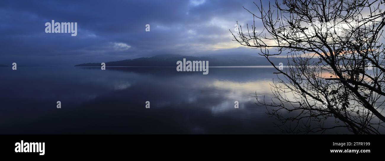 Ein nebeliger Sonnenaufgang über Loch Lomond von Duck Bay, Balloch Village, West Dunbartonshire, Schottland, Großbritannien Stockfoto