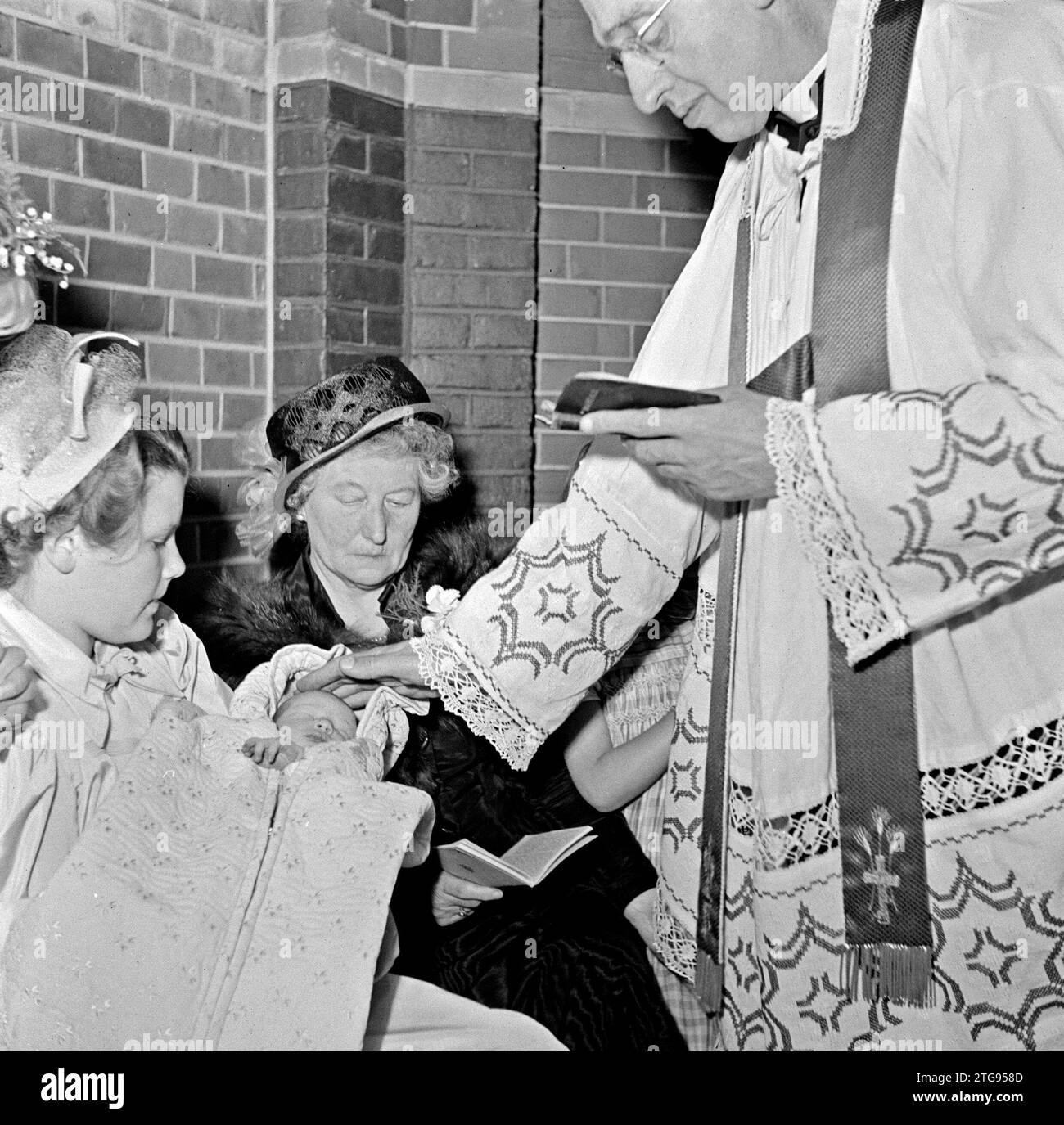 Kleriker tauft Baby Ca. Mai 1950 Stockfoto