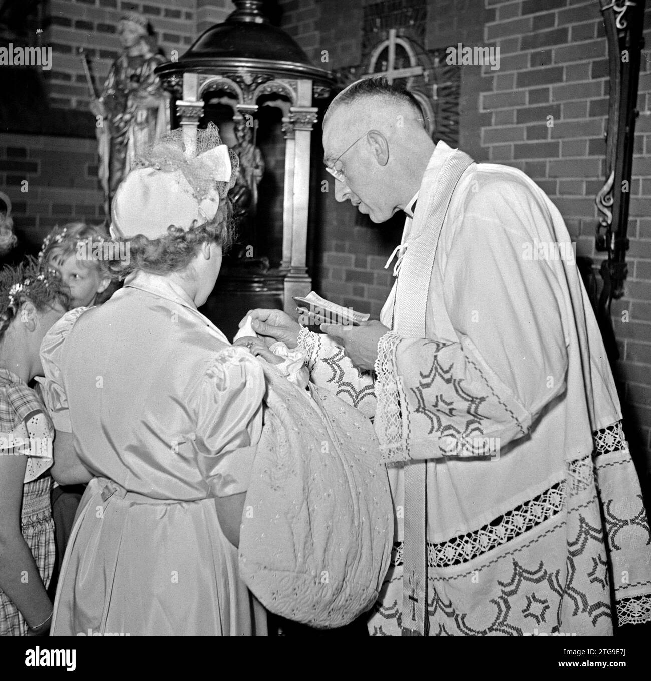 Der Kleriker tauft ein Kleinkind Ca. Mai 1950 Stockfoto