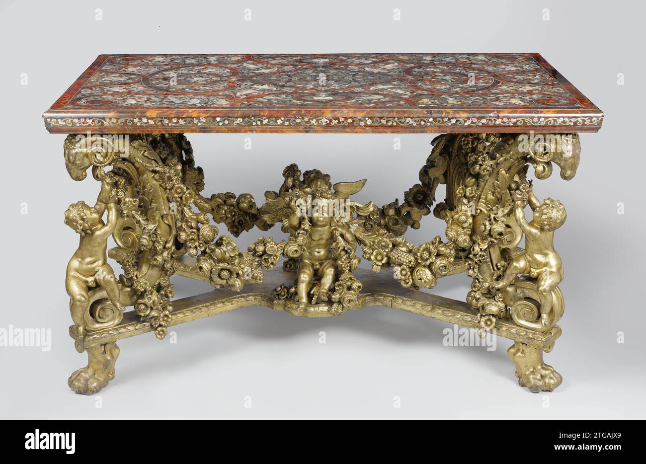 Tisch, loser Pieter, 1689 Tisch mit Rahmen aus Skulptur und vergoldetem Lindehout. Das X-förmige Kreuz liegt auf Löwenklauen und trägt große C-förmige Voluten, die in einem Ramskop enden und darunter in einer Volute. An der Kreuzung befindet sich eine Kinderfigur, die zusammen mit dem Kleben von Kinderfiguren auf den Voluten eine Obst- und Blumengirlande stoppt. Das rechteckige Blatt ist komplett mit Grotesken bedeckt, die in Kupfer und Perlmutt auf einem Schaft von Schildkröten ausgeführt wurden; aus diesem Grund läuft ein Geflechtband-Motiv, in dem zwei Familienwaffen verlaufen. Antwerpener Holz (Pflanzenmaterial). linden. Vergoldung (Material). Eiche (W Stockfoto