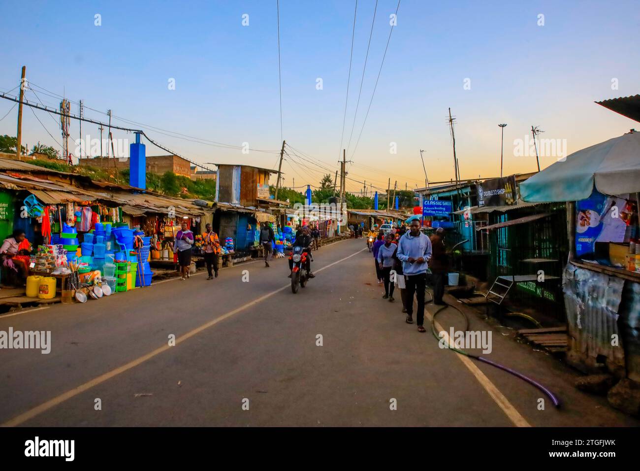 Fußgänger gehen an den geschäftigen Straßen in Kibera Slum in Nairobi, Kenia vorbei. Ein Blick durch den Alltag in Kibera, dem derzeit größten Slum an Afrikas Stockfoto