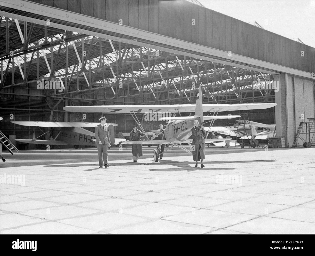 Die Pander EF 85 Doppeldeckerregistrierung PH-AFZ, Ausbildungsflugzeug der National Aviation School in Amsterdam Schiphol, wird von zukünftigen Piloten aus dem Hangar gedrängt. CA. Februar 1931 Stockfoto