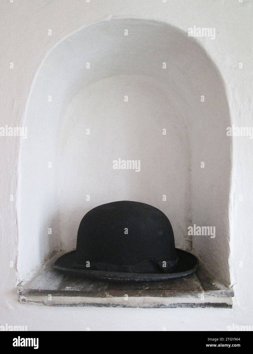Konzeptkunst, schwarzer Bowler Hut in weißer Nische, wo immer ich meine Mütze lege, ist mein Zuhause. Historisches Image, Tudor-Raum für Waren/Kleidung weg von Nagetieren Stockfoto