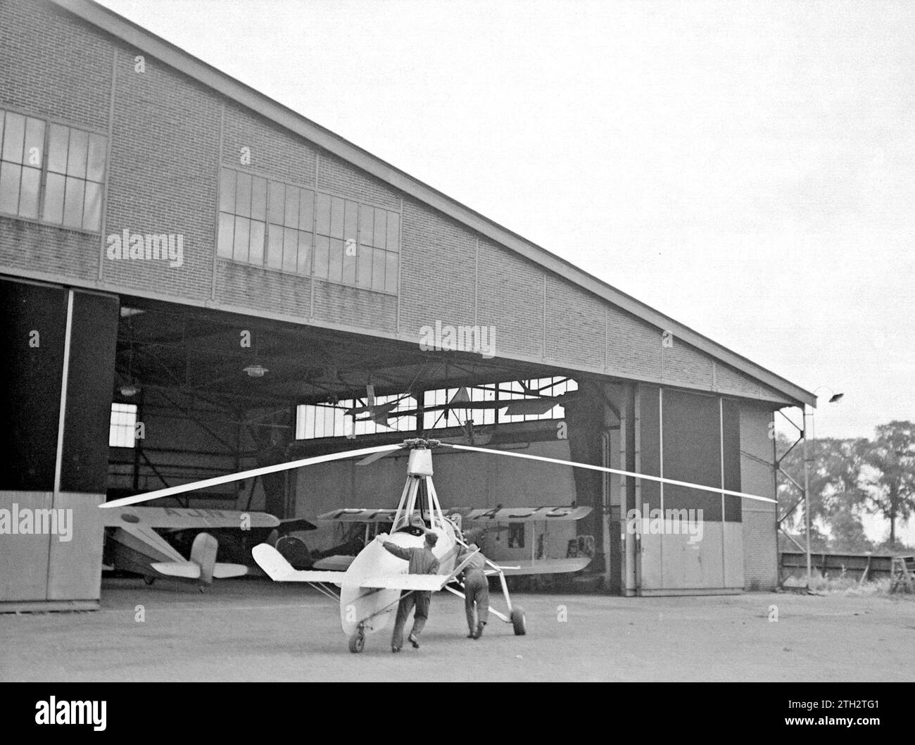 Die Cierva autogyro PH-HHH (Donna Dulcinea) der Niederländischen Luftfahrtschule wird in den Hangar am Flughafen Rotterdam Waalhaven gefahren. 1935 Stockfoto