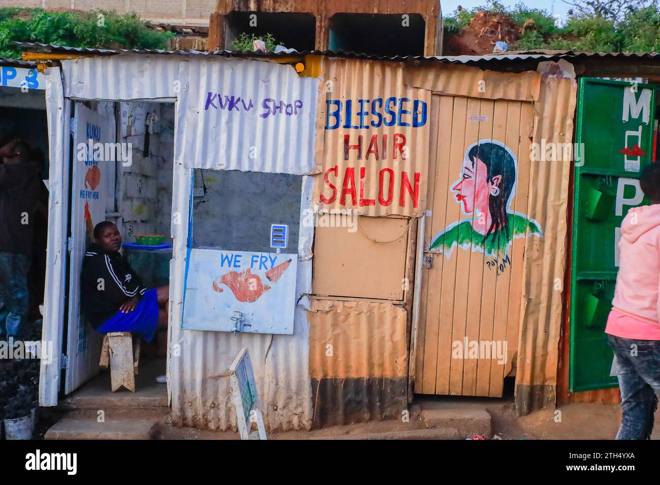 Eine Frau sitzt in ihrem Geschäft in Kibera Slum, Nairobi. Ein Blick durch den Alltag in Kibera derzeit Afrikas größtem Slum und den Tag bis zum Tag Stockfoto