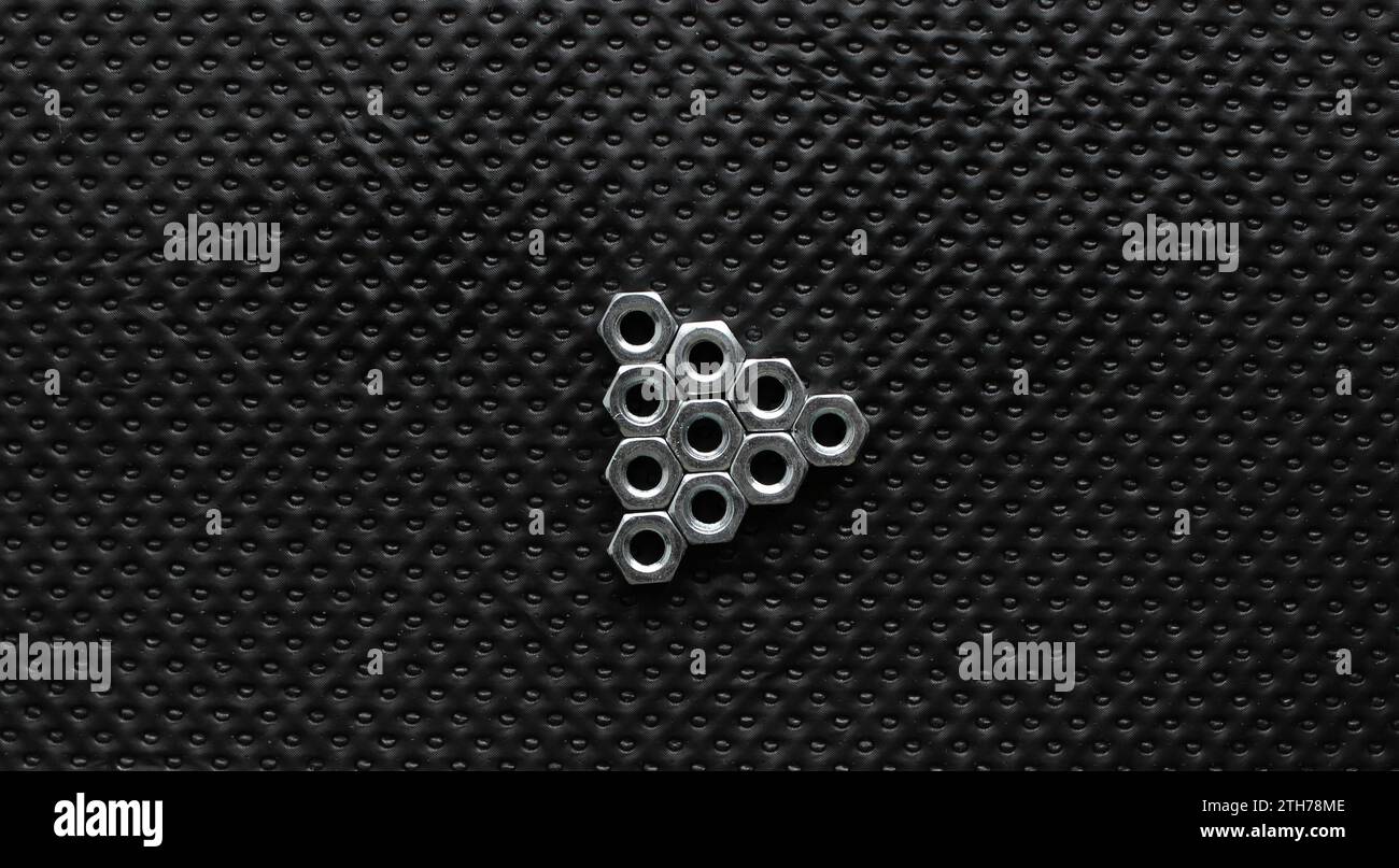 Dreieck-Medienwiedergabe-Symbol Von Muttern Auf Schwarzer Perforierter Oberfläche Stockfoto