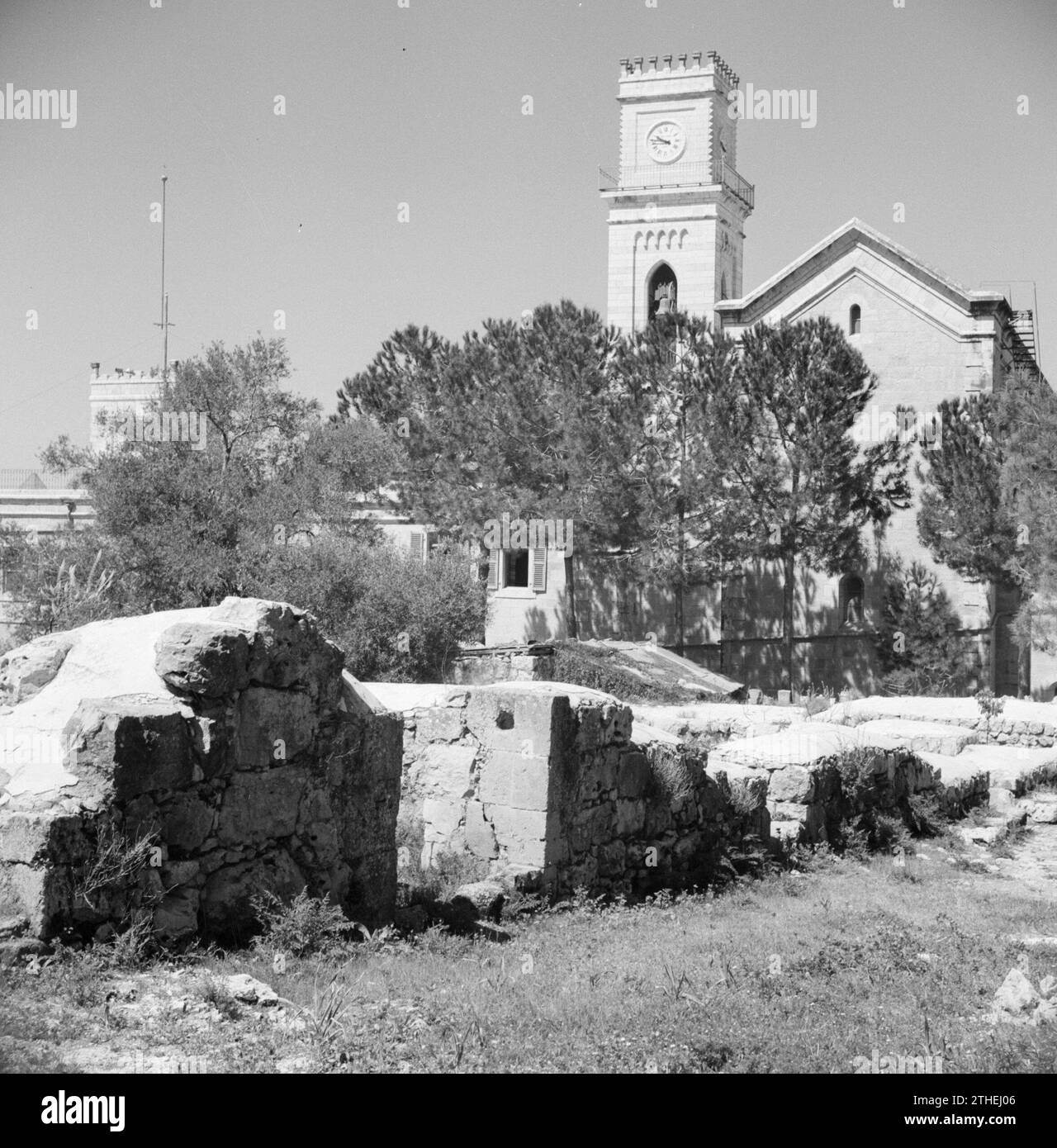 Kirche mit Turm und römischen Überresten im Vordergrund ca. 1950-1955 Stockfoto