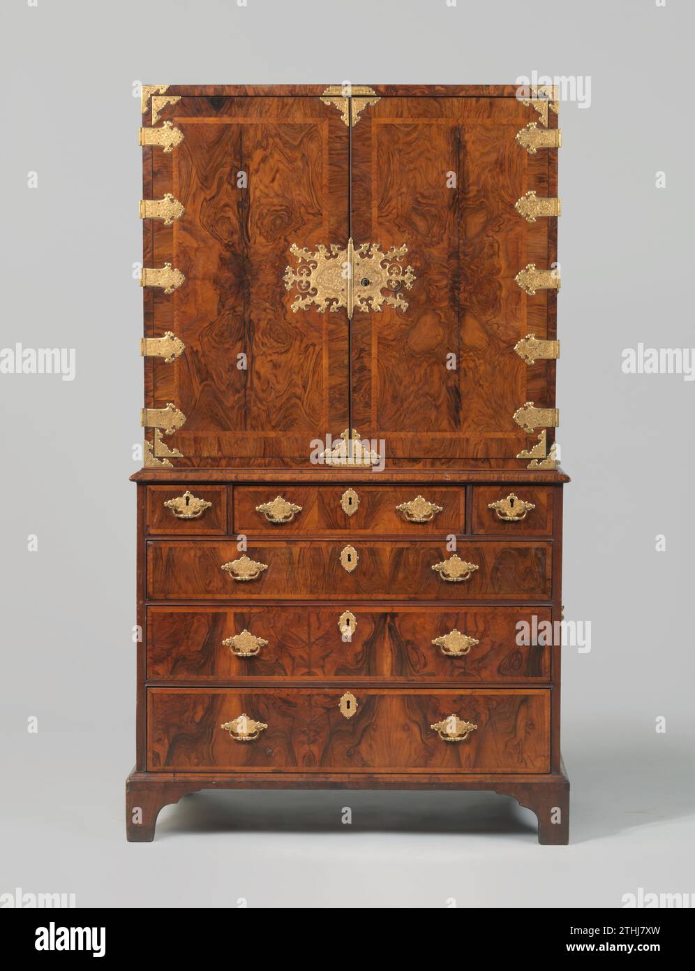 Schrank mit Karottennussholz verklebt, anonym, ca. 1675 - ca. 1700 Schrank mit Wurzelnussholz auf Eichenkern, unterteilt in Ober- und Oberschrank, dekoriert mit Schlossplatten, Eckstücken, Scharnieren und Traktoren mit geätzten, vergoldeten Kupferplatten. Kupfergriffe auch mit Platten an den Seiten. Der obere Schrank verfügt über zwei Vordertüren, hinter denen 12 Schubladen unterschiedlicher Breite, mit Traktoren und Platten wie außen. Das Chassis verfügt über drei Schubladen über die gesamte Breite und drei schmalere Schubladen oben. Die Füße sind an den Ecken abgeschnitten. Grossbritannisches Holz (Pflanzenmaterial). Eiche (Holz). copp Stockfoto