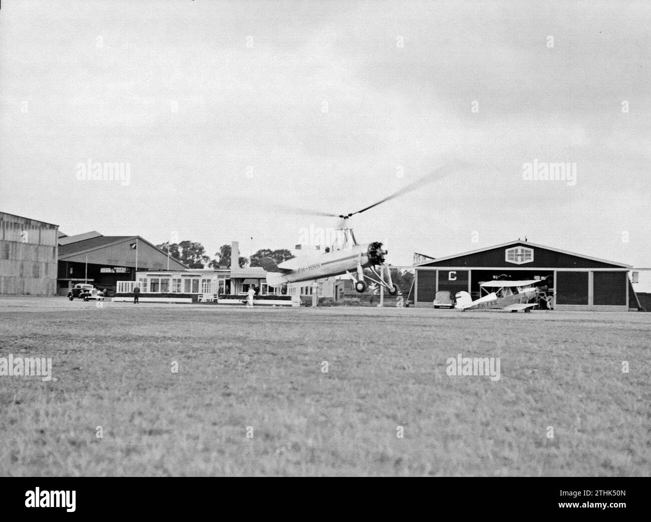 Der Start des Cierva autogyro PH-HHH (Donna Dulcinea) der Niederländischen Luftfahrtschule am Flughafen Rotterdam Waalhaven. Rechts ein Koolhoven Doppeldecker der PH-FKE CA. 1935 Stockfoto