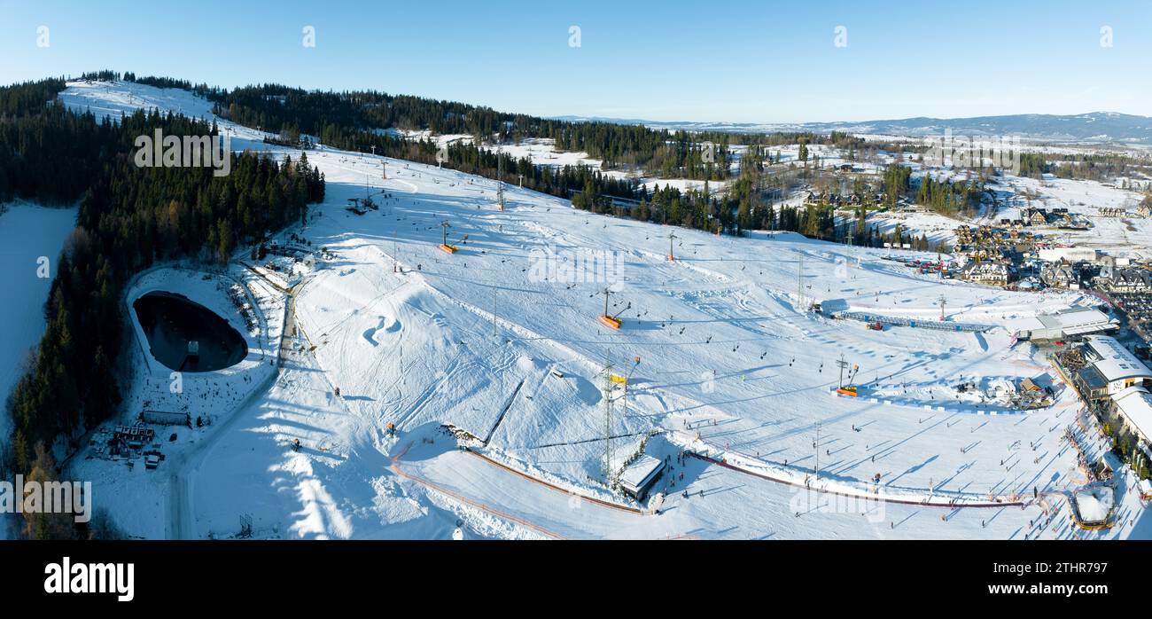 Skipiste, Sessellifte, Skifahrer und Snowboarder im Winter im Skigebiet Bialka Tatrzanska in Polen auf dem Berg Kotelnica. Luftpanorama im niedrigen Dezember Stockfoto