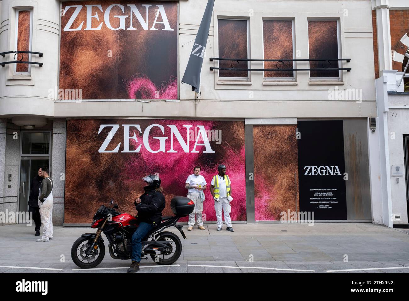 Arbeiter interagieren am 16. Oktober 2023 mit einem neuen Werbespot für Zegna in der Bond Street in London, Großbritannien. Bond Street ist eine der wichtigsten Straßen im West End Einkaufsviertel und ist sehr hochwertig. Es ist seit dem 18. Jahrhundert eine modische Einkaufsstraße. Das reiche und wohlhabende Geschäft hier ist hauptsächlich für High-End Mode und Schmuck. Stockfoto