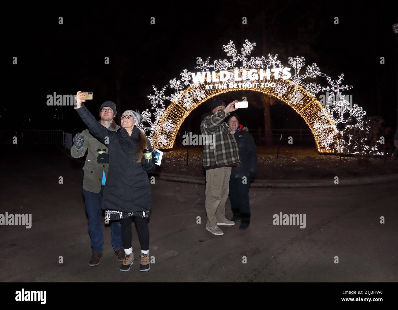 Menschen, die die Weihnachtsbeleuchtung des Detroit Zoo Wild Lights genießen, und Selfies bei der Weihnachtsbeleuchtung machen Stockfoto