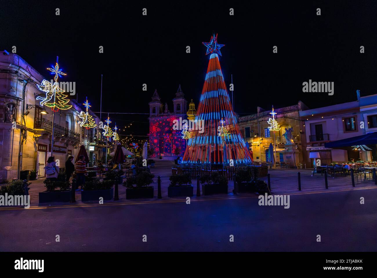 Lasershow auf einer Kirchenfassade und beleuchteter Weihnachtspyramide. Die Plätze in Malta werden vor Weihnachten in farbenfrohes Licht getaucht. Marsaxlokk, Malta Stockfoto