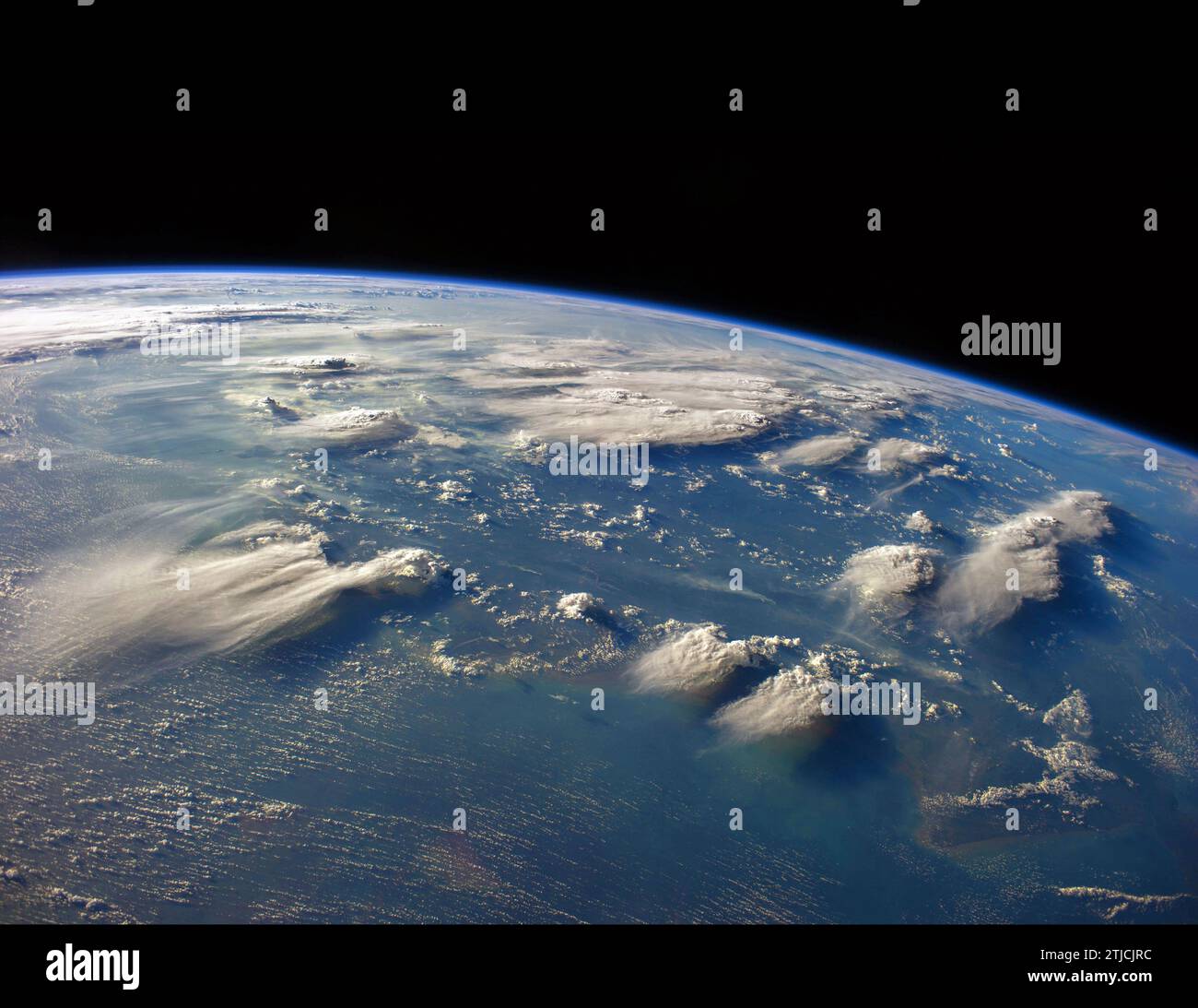 In diesem Bild, das von einem Besatzungsmitglied der Expedition 40 auf der Internationalen Raumstation aufgenommen wurde, sind Gewitterköpfe in der Nähe von indonesischem Borneo zu sehen. Die Winde wehen in der Regel in verschiedene Richtungen in unterschiedlichen Höhen. Höhenwinde ziehen die Gipfel deutlich von den höchsten Gewitterwolken und erzeugen lange Ambosse von diffusen Zirrusfedern, die sich nach Süden ziehen. In niedrigen Niveaus sind „Straßen“ mit weißen Punkten – Schönwetter-Cumulus-Wolken – mit westbeweglichen Winden ausgerichtet (unten links). Kleine Rauchwolken von Waldbränden an Land passen ebenfalls die westlich optimierte Version eines Originalbildes der NASA an Stockfoto