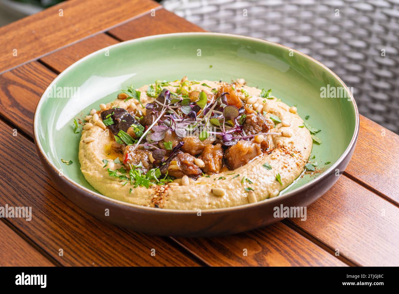 Hummus mit warmer Aubergine in süßer Chilisauce. Gesundes veganes Essen, israelische Küche. Stockfoto