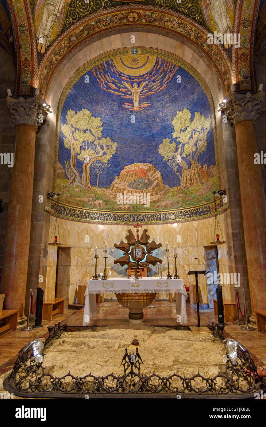 Die Kirche aller Nationen, auch bekannt als Kirche oder Basilika der Qualen, ist eine römisch-katholische Kirche auf dem Ölberg in Ost-Jerusalem, neben dem Garten Getsemani. Es ist ein Teil des Grundfeldes, auf dem Jesus vor seiner Verhaftung gebetet haben soll. Das ist der Hochaltar, der Felsen, auf dem Jesus gebetet haben soll. Die Platte ist von einem schmiedeeisernen Kranz umgeben, der die Dornenkrone darstellt. Viele Anbeter berühren den freiliegenden Felsen, während sie ihr eigenes Gebet vor Gott darbringen. Kredit: Digitaleye/JdeSousa Stockfoto