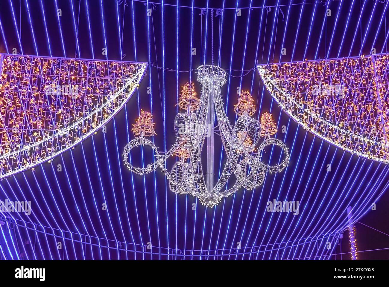 Detail eines Kronleuchters, der an einer blauen Decke aus Weihnachtslichtern hängt, als Dekoration im Rathaus von Sevilla, um die Kathedrale herum, bei christmas tim Stockfoto