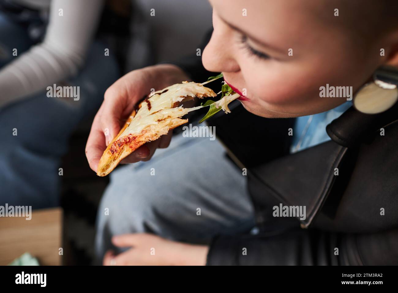 Ein Junges Mädchen Beißt Käse-Pizza Stockfoto