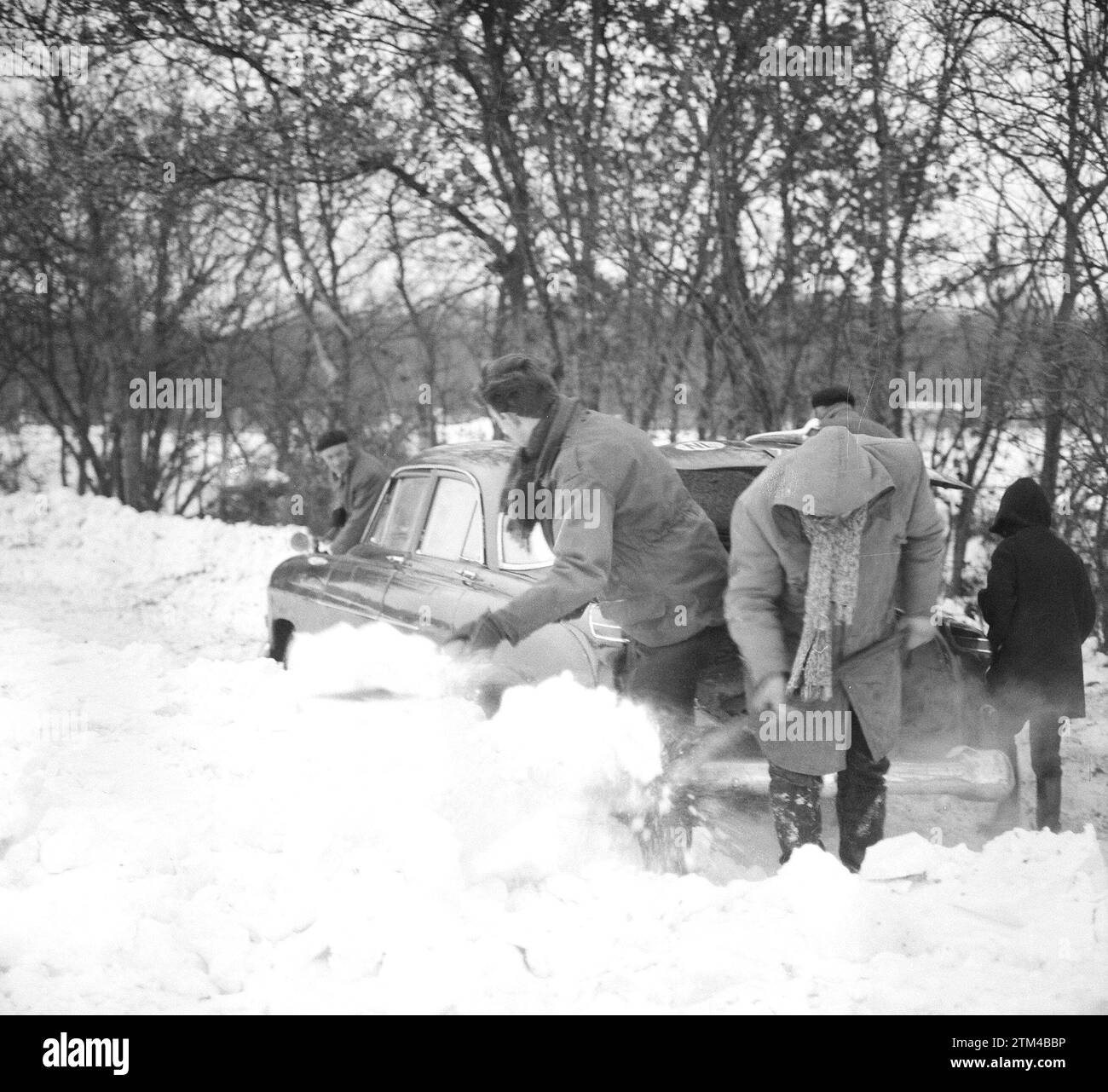 Autos schneite rein, Leute graben ein Auto aus. Januar 1963 Stockfoto