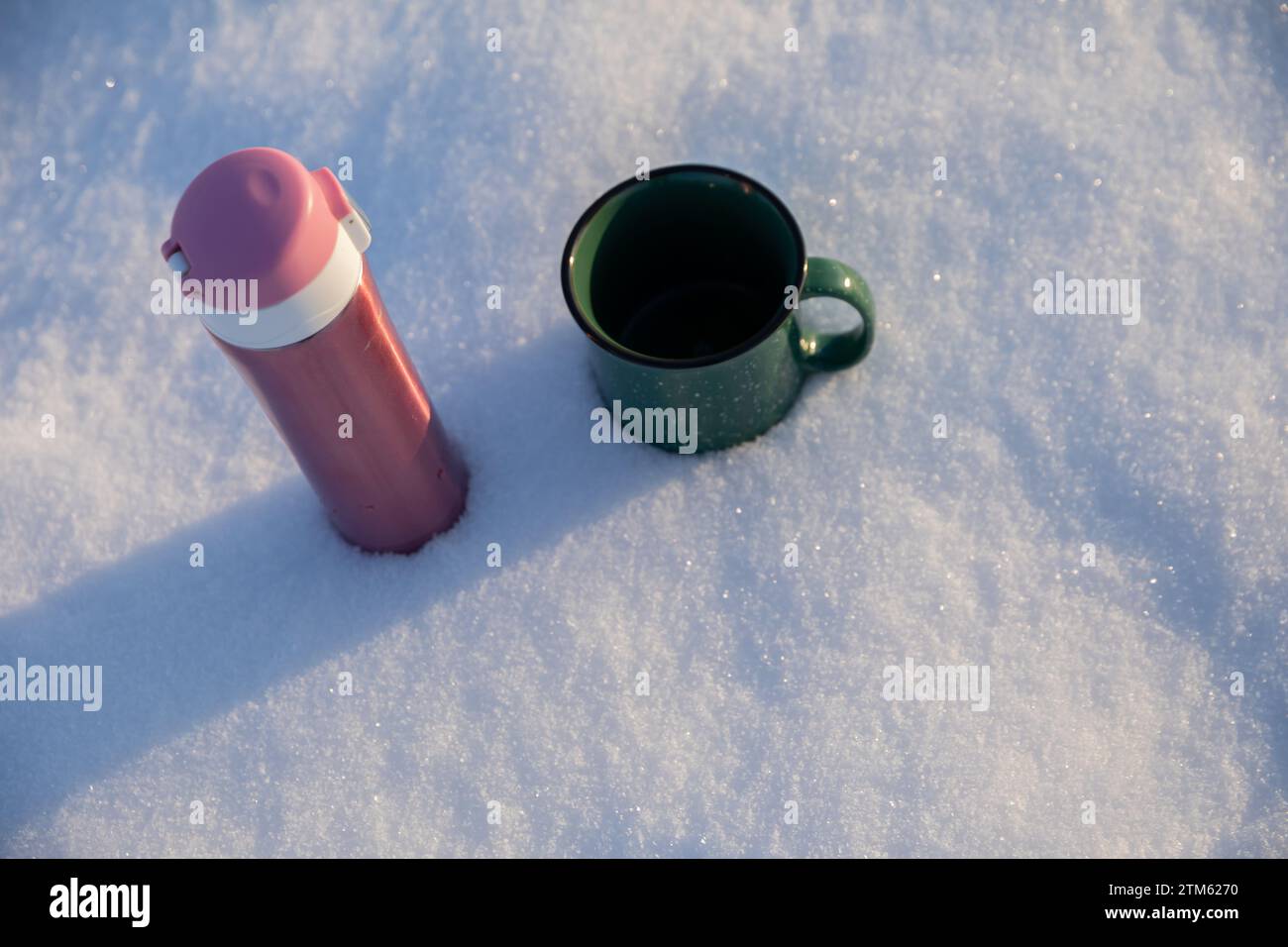 Zwei Tassen stehen im Schnee, von oben gesehen. Stockfoto