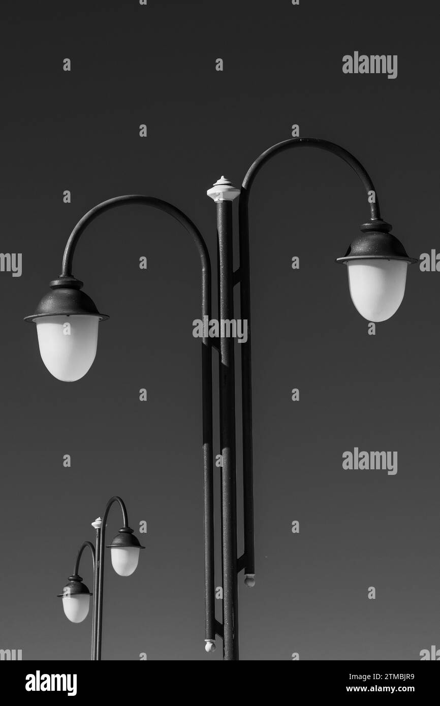 Schwarze Straßenlaternen, klarer Himmel als Hintergrund. Schwarz und weiß, Farben. Schwarzweiß. Stockfoto