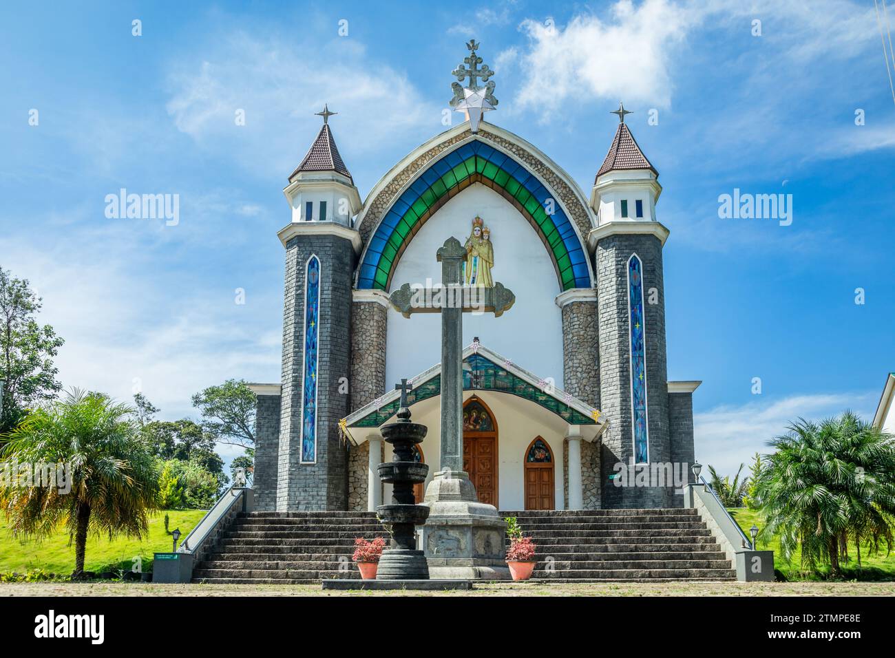 Velankanni Matha katholische Kirchenfassade mit Kreuz, Palmen und Treppen im Vordergrund, Nedumkandom, Kerala, Südindien Stockfoto