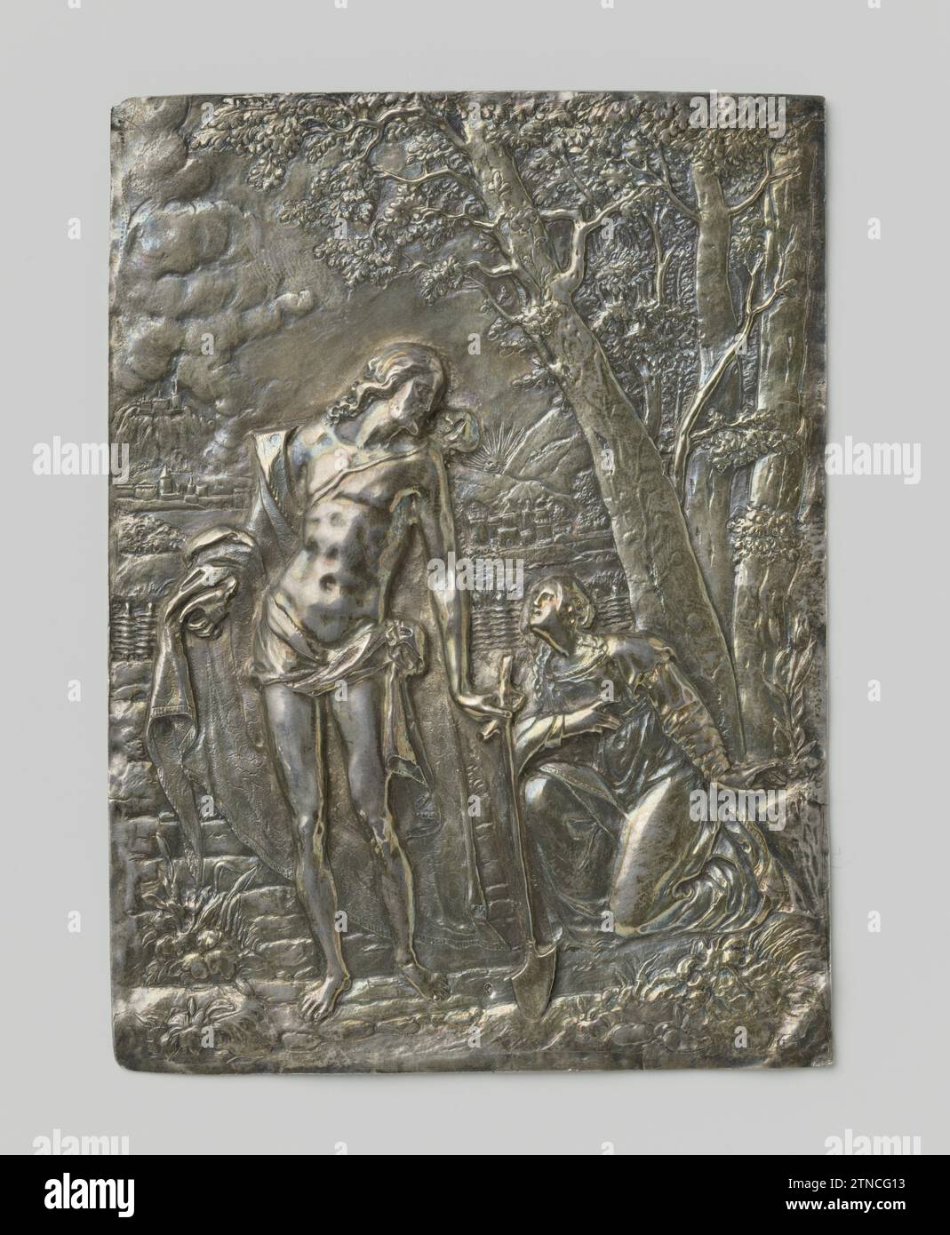 Christus als Gärtner, Joost Lutma (zugeschrieben), 1649 rechteckige, silberne Tafel. Die Figur des Christus trägt einen Lendenschurz und einen Mantel, weit über den Schultern gefaltet. Mit einer Schaufel in der linken Hand bewegt er sich nach links, während er rechts von seiner knienden Maria-Magdalena hinunterschaut. Hinter ihr eine schwere Baumgruppe. Links, hinter einem Geflechtzaun, eine Berglandschaft mit Gebäuden. Niederlande Silber (Metall) rechteckig, silberne Plakette. Die Figur des Christus trägt einen Lendenschurz und einen Mantel, weit über den Schultern gefaltet. Mit einer Schaufel in der linken Hand bewegt er sich nach links, während er es sieht Stockfoto